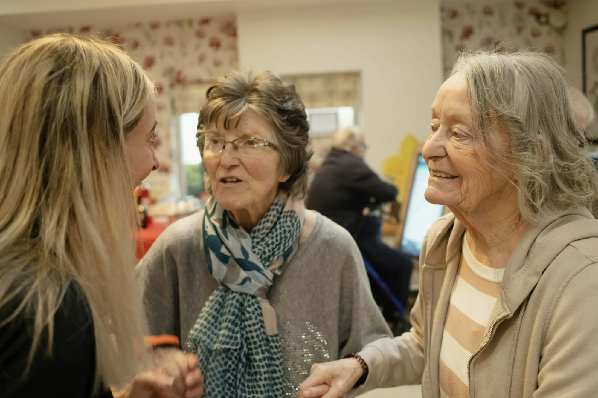 A care worker sitting and talking with an older woman at home