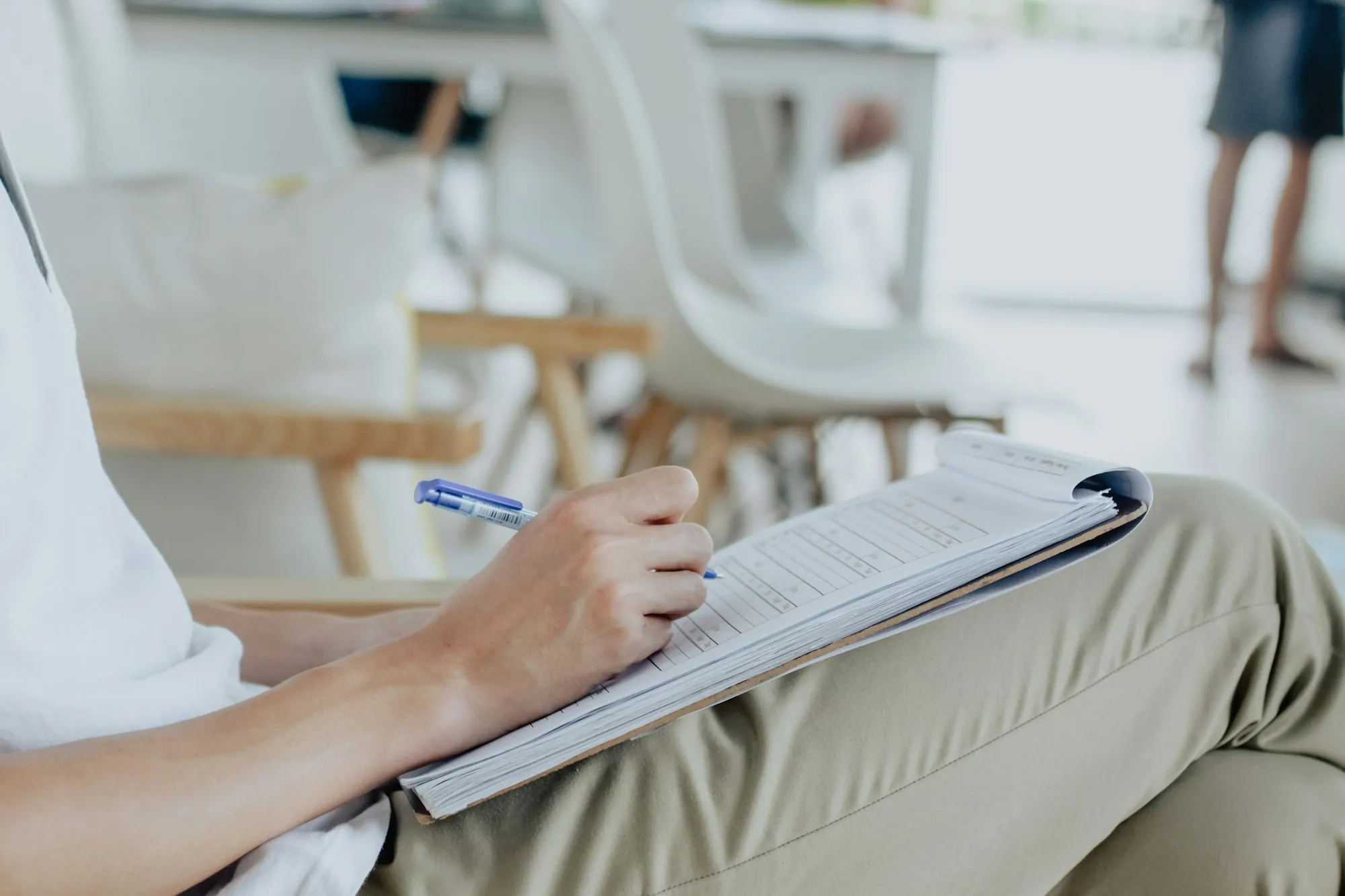 An open notebook with a pen and pencils on a desk